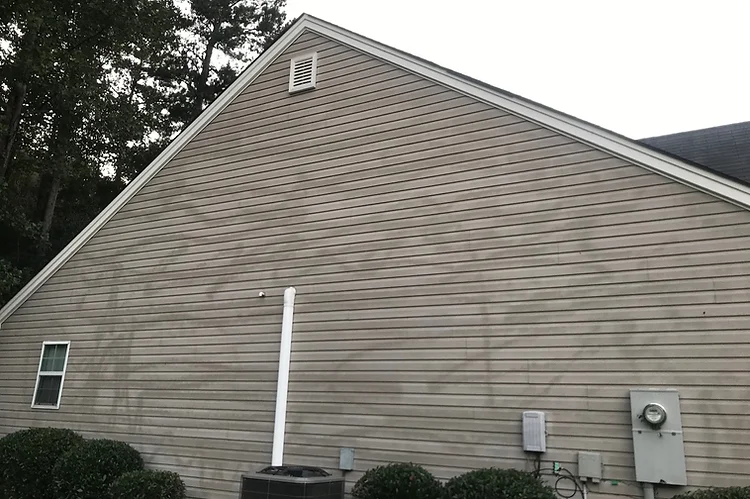 damaged vinyl siding on house from pressure washer